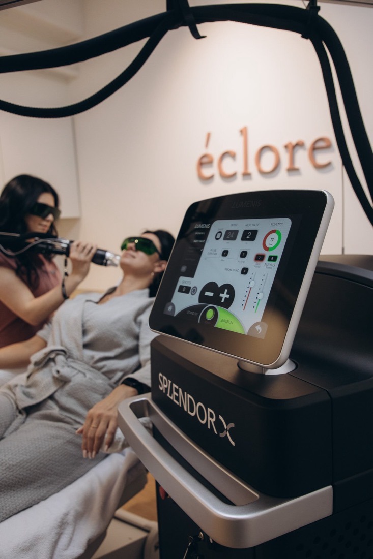 SplendorX 1.9 console beside a treatment chair at Éclore Clinics while a therapist performs a facial laser hair removal session